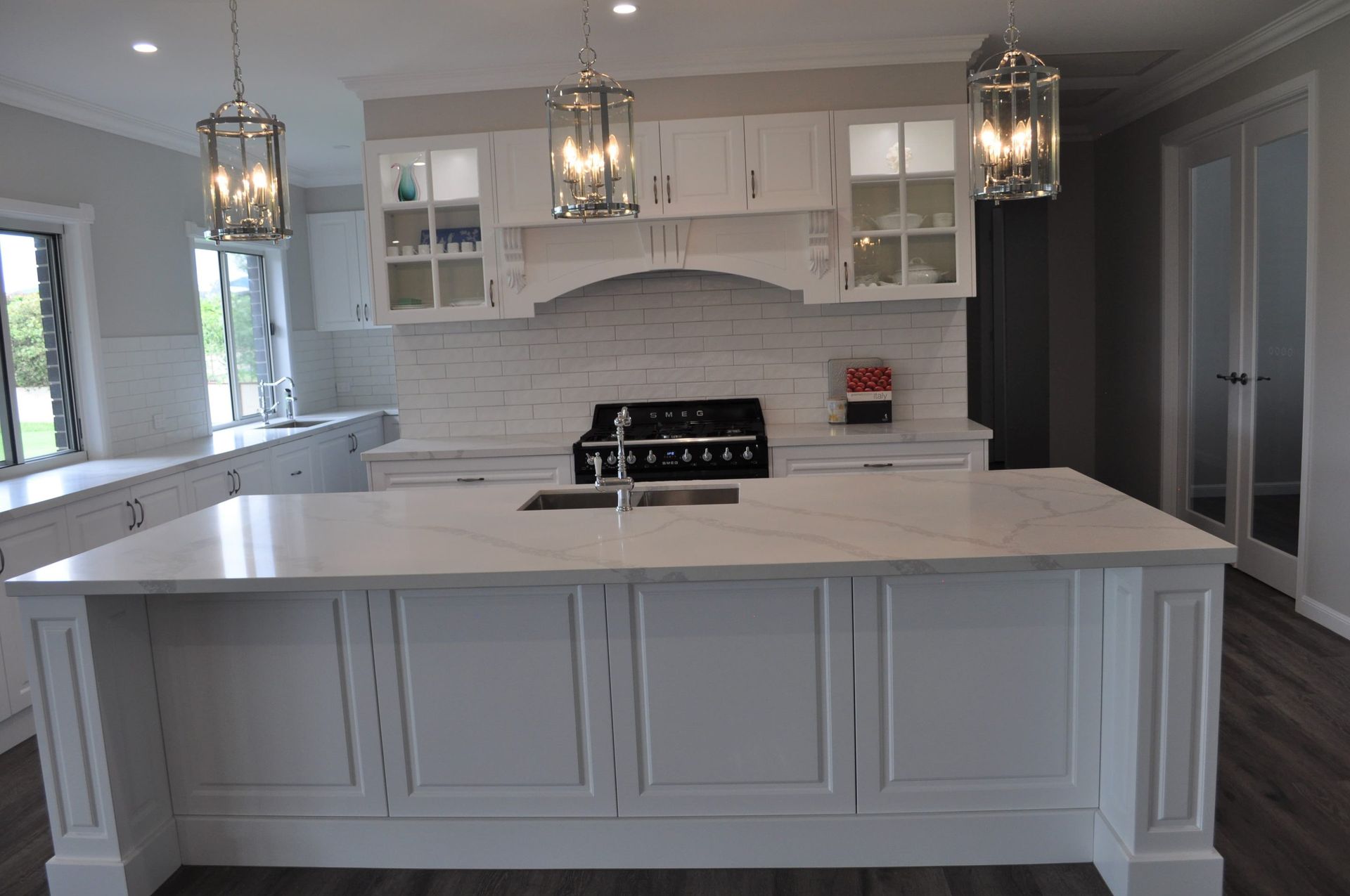 A Modern White Kitchen Featuring a Large Island With a Sink — Craftsmen Kitchens In Monkland, QLD