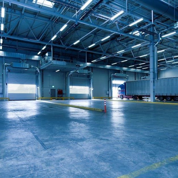 A large warehouse with a truck parked inside of it.