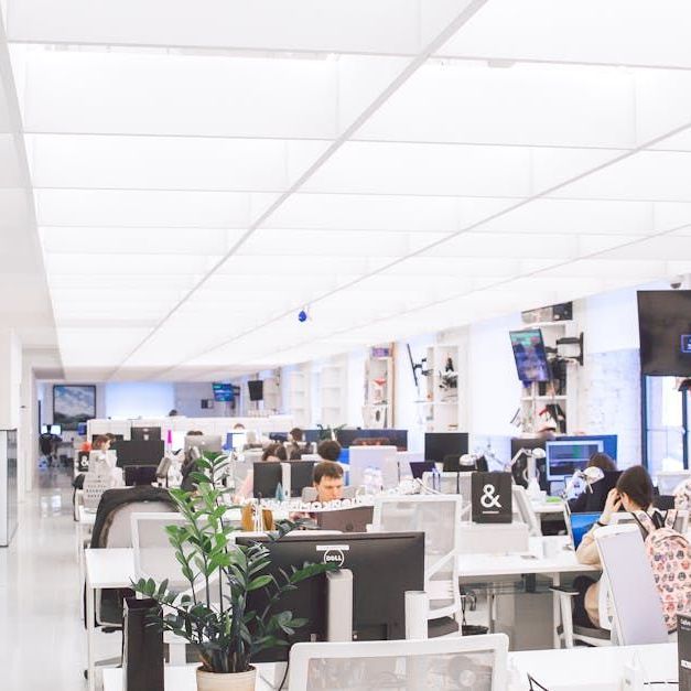 A large office with lots of people working on computers
