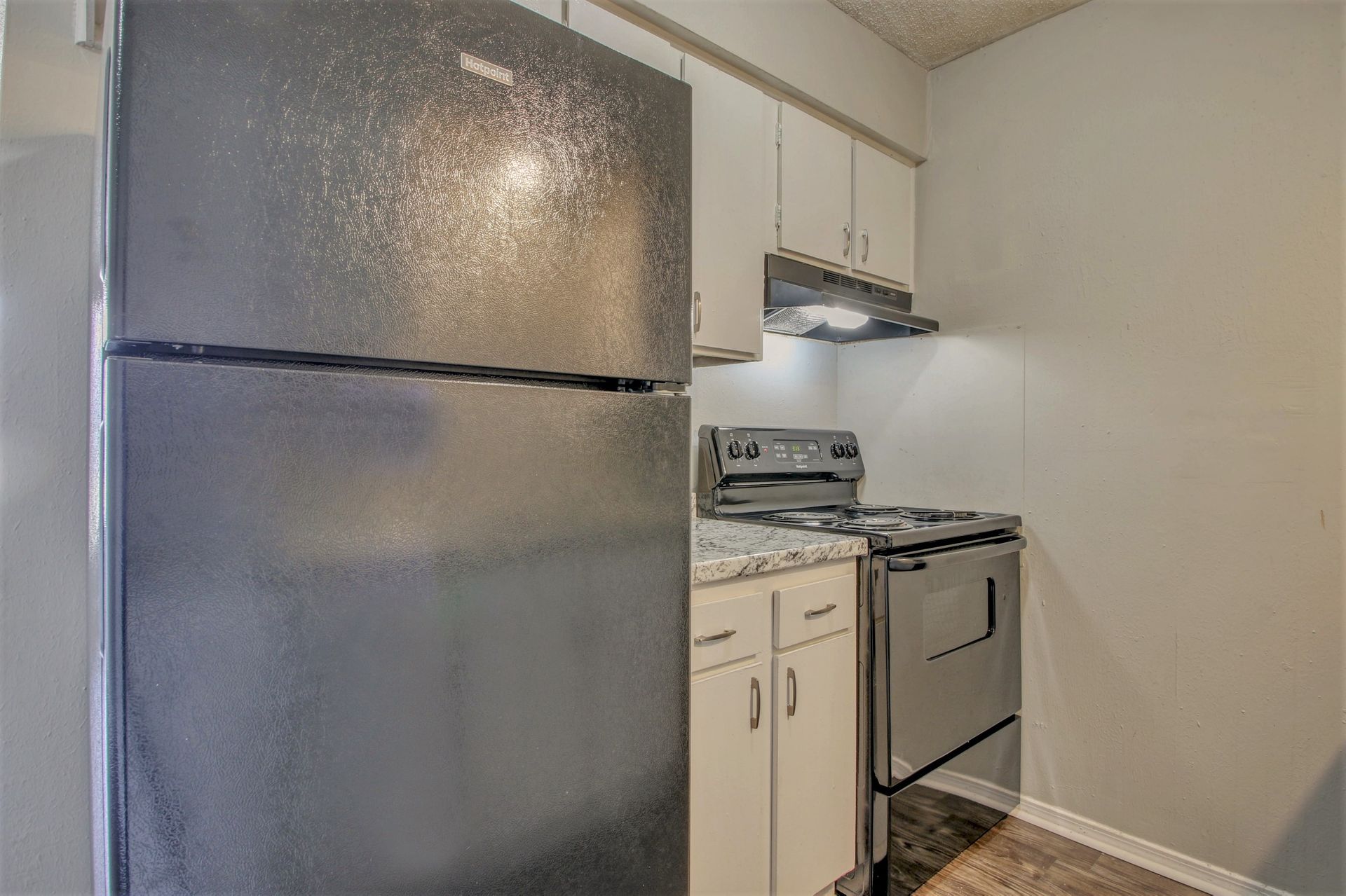 A kitchen with a refrigerator , stove , and cabinets.