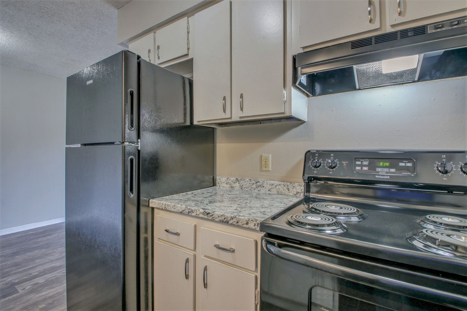 A kitchen with a refrigerator , stove , and microwave.