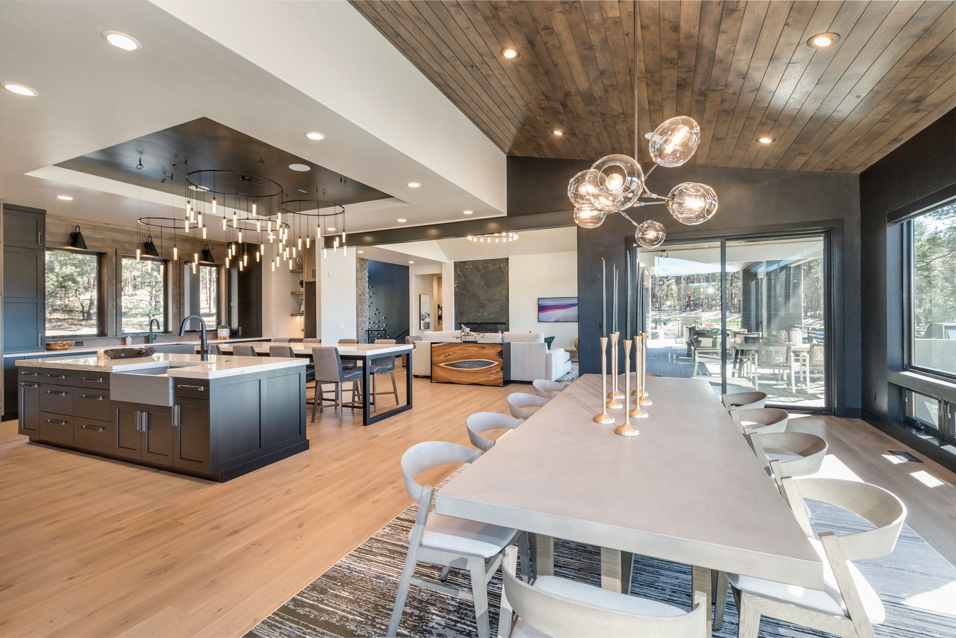 Modern open-concept kitchen and dining area with island, pendant lights, and large glass doors