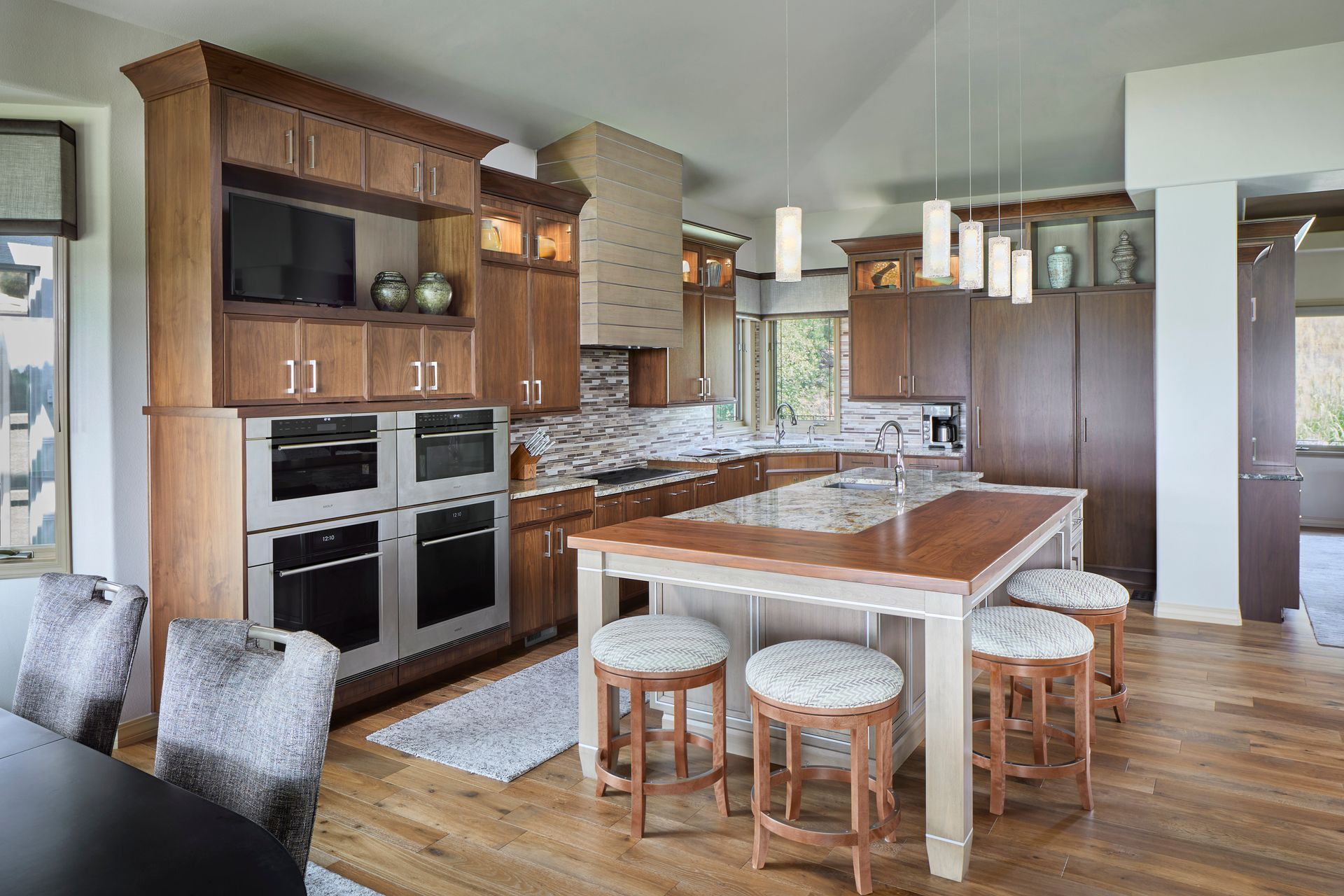 Modern kitchen with wood cabinets, island, bar stools, and stainless appliances