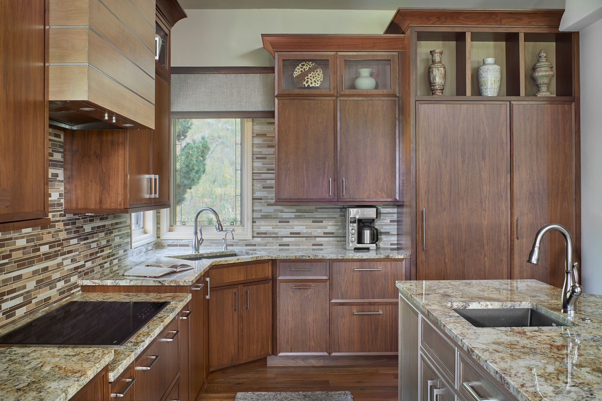 Modern kitchen with wood cabinets, stone counters, mosaic backsplash, and a sink by a window