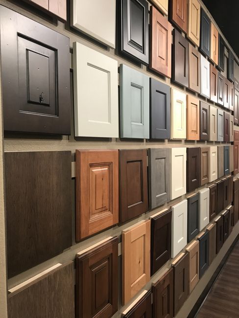 Display wall of cabinet door samples in various colors and wood finishes inside a showroom