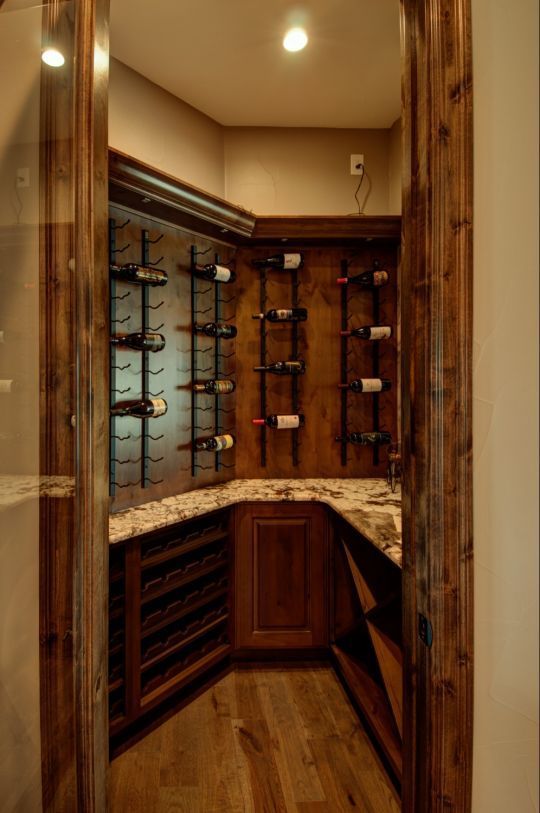 Small wooden wine cellar with built-in bottle racks and warm lighting