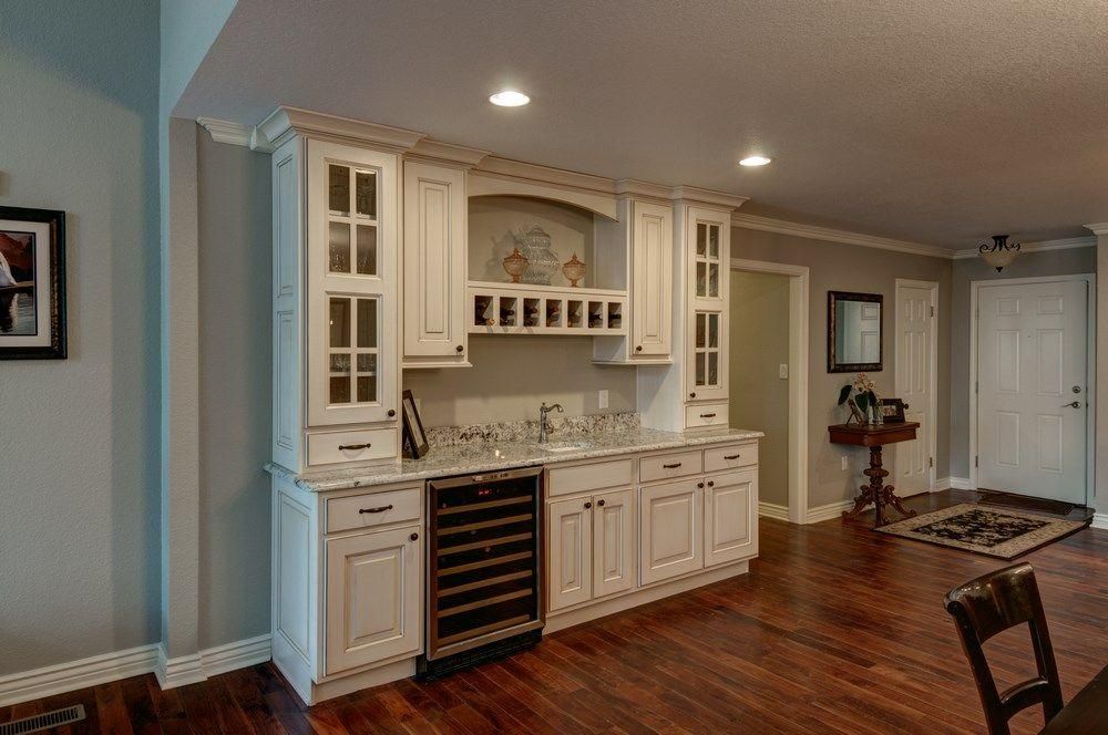 Bright dining area with a built-in cream cabinet, wine fridge, hardwood floors, and recessed lighting