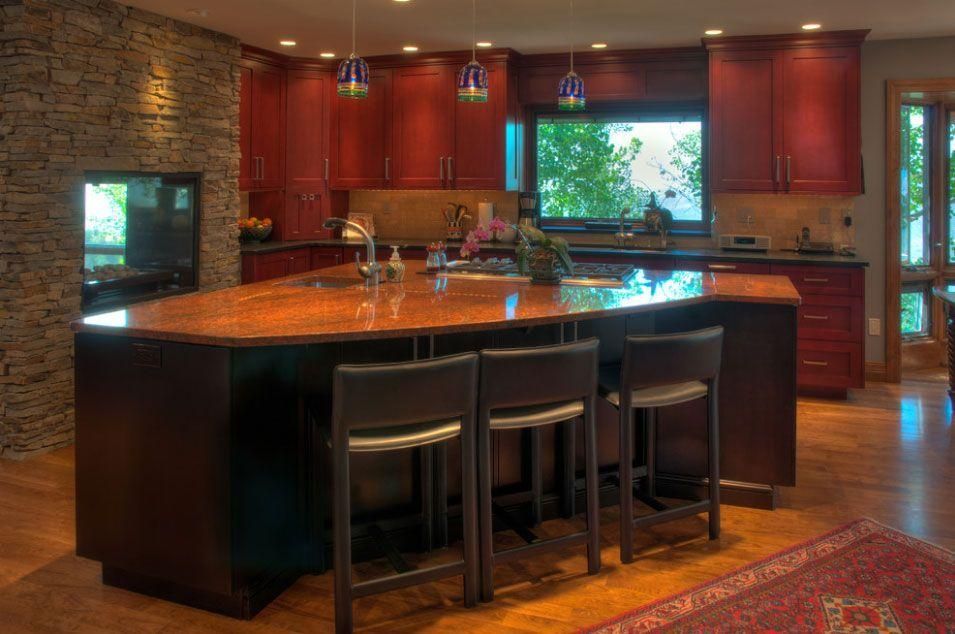 Modern kitchen with a large island, dark wood cabinets, and warm lighting