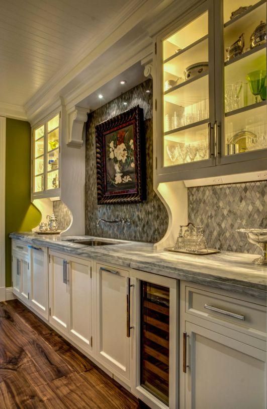 Built-in cabinetry and shelves in a warmly lit hallway with decorative artwork and wood flooring
