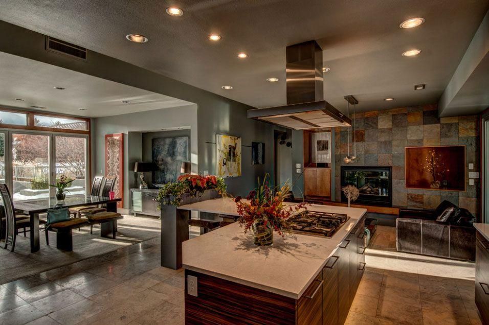 Modern open-concept kitchen and living room with island, fireplace, and large windows