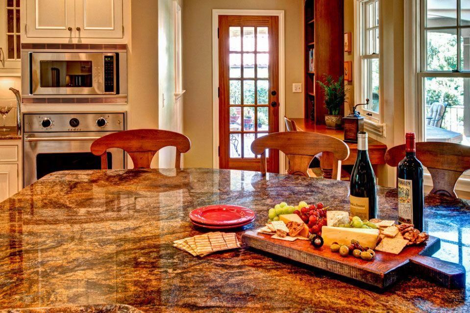 Kitchen island with fruit, cheese, wine, and glasses in a bright modern kitchen