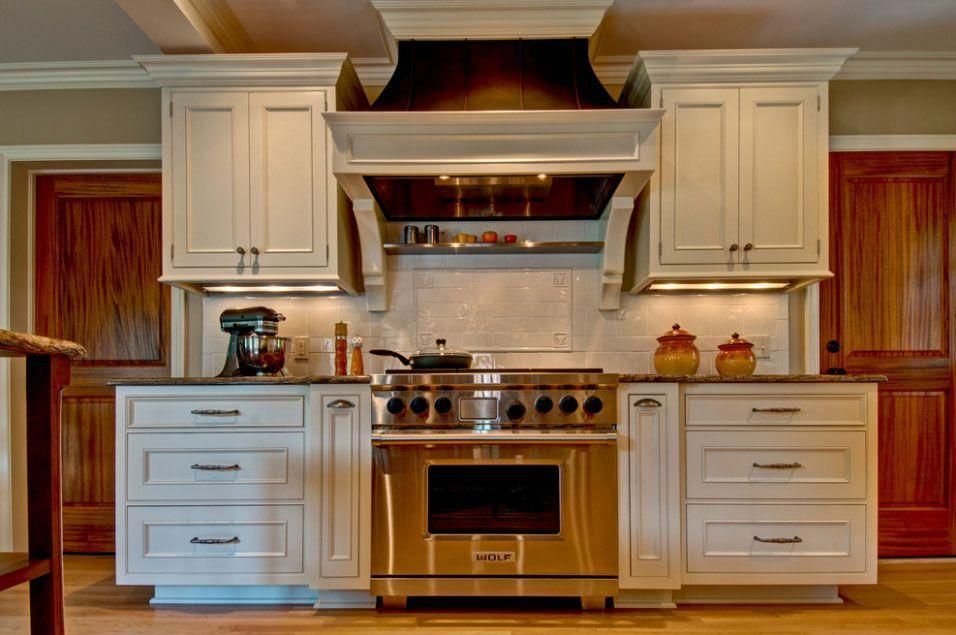 Elegant kitchen with white cabinets, stainless steel stove, and wood-paneled backsplash