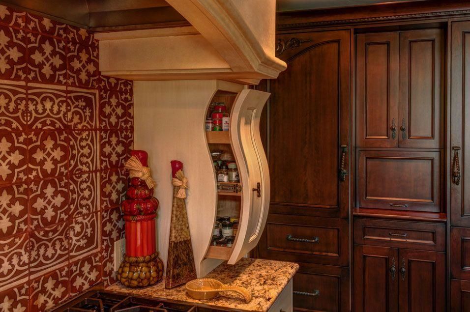 Decorative wall niche with vases and mirror beside dark wooden cabinets in a warm-toned room