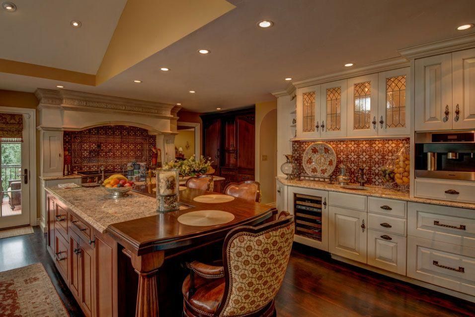Warm kitchen with large island, cream cabinets, tiled backsplash, and recessed lighting