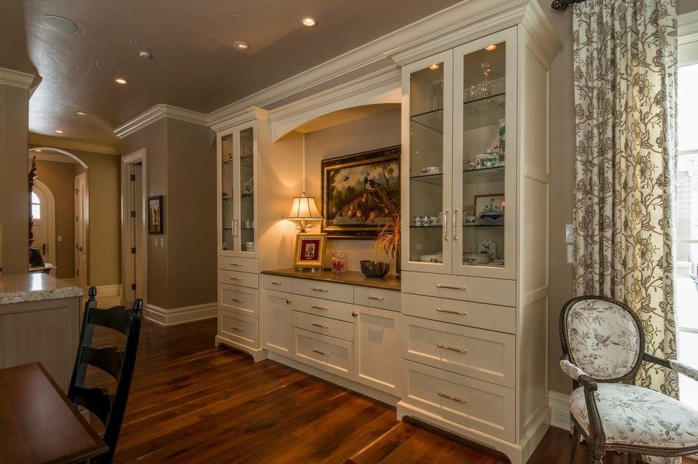 Elegant dining room with built-in white cabinets, hardwood floors, and a table by the window.