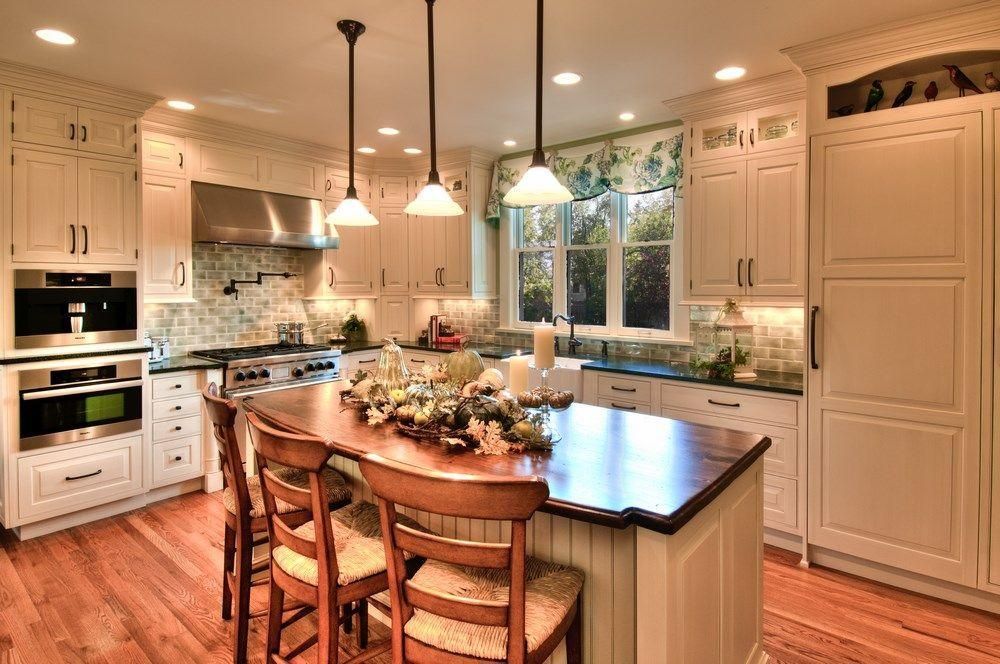 Bright modern kitchen with island, white cabinets, and hardwood floors