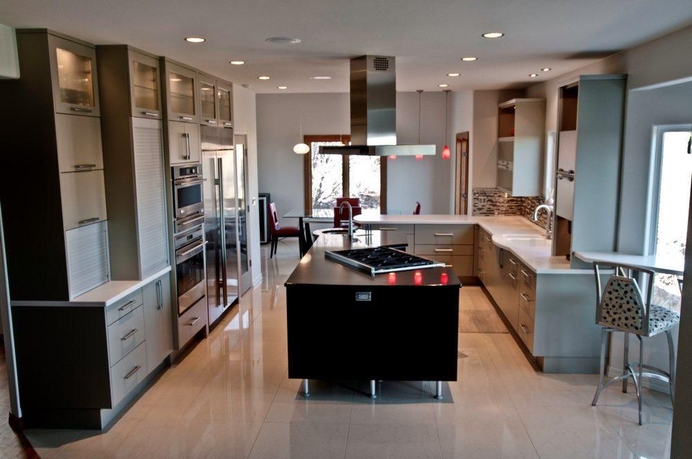 Modern kitchen with island, stainless appliances, and a breakfast bar by a large window