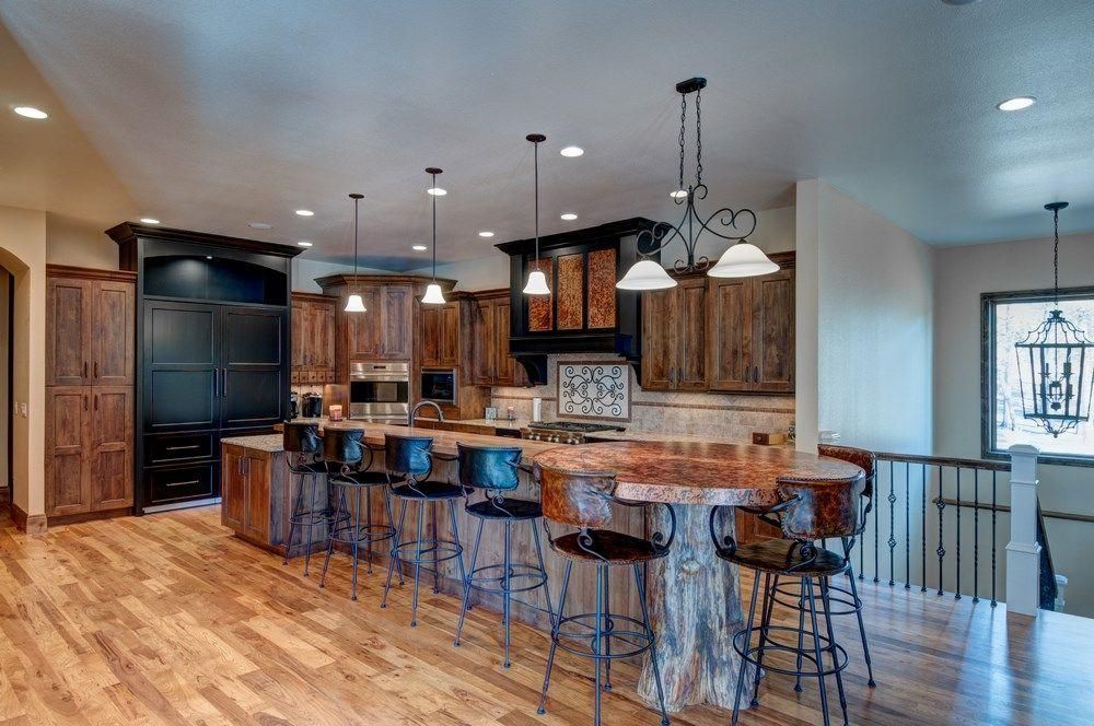 Modern kitchen with island seating, wood cabinets, stainless appliances, and hardwood floors