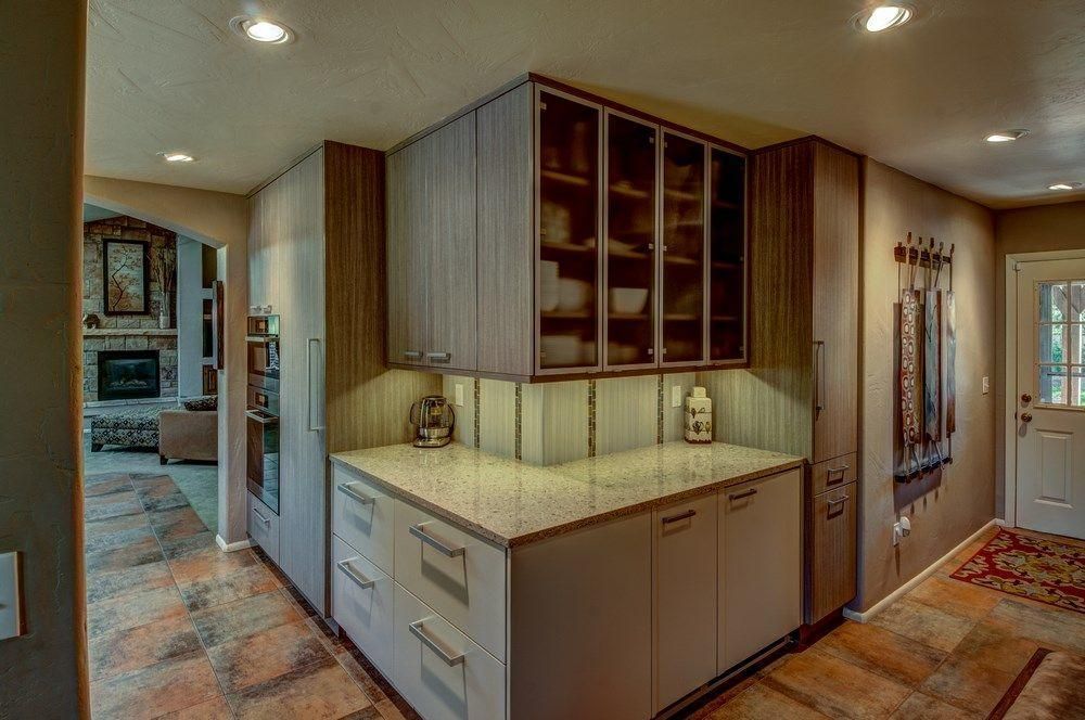 Hallway with built-in cabinets, wood accents, recessed lighting, and a view into another room