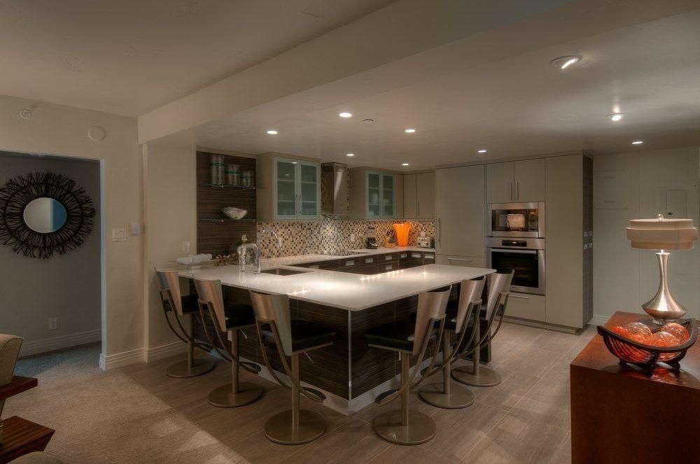 Modern kitchen with a large island, bar stools, recessed lighting, and stainless steel appliances