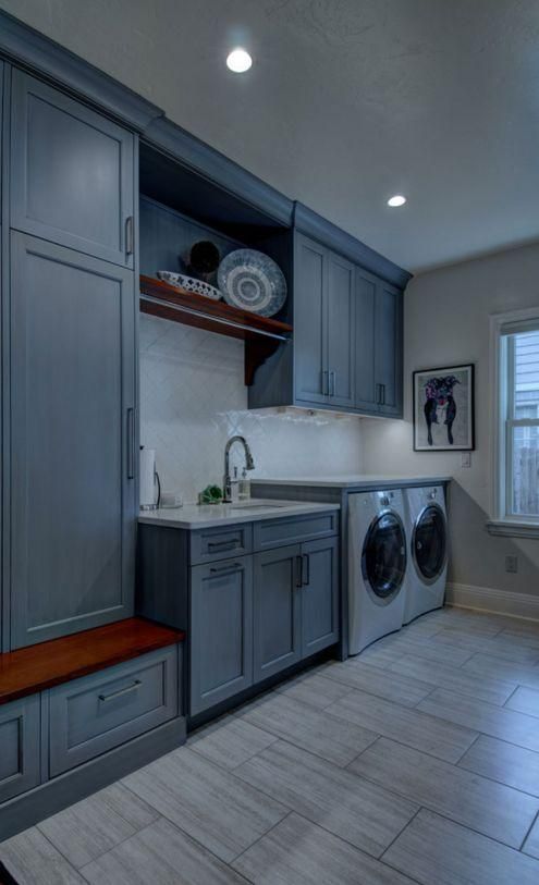 Modern laundry room with gray cabinets, sink, washer-dryer, tiled floor, and recessed ceiling lights