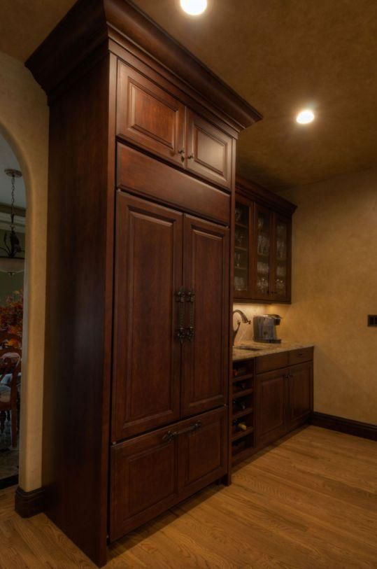 Built-in dark wood cabinets and wine storage in a warmly lit kitchen nook
