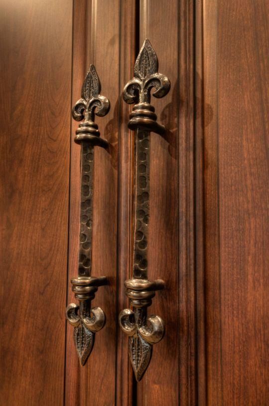 Ornate bronze handles on a wooden cabinet door