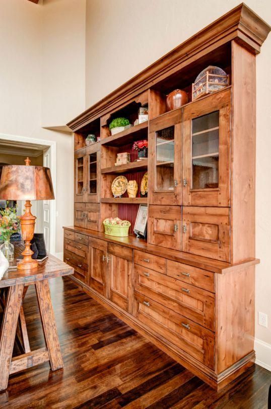Wooden built-in hutch with shelves and cabinets in a warm-toned hallway or dining area