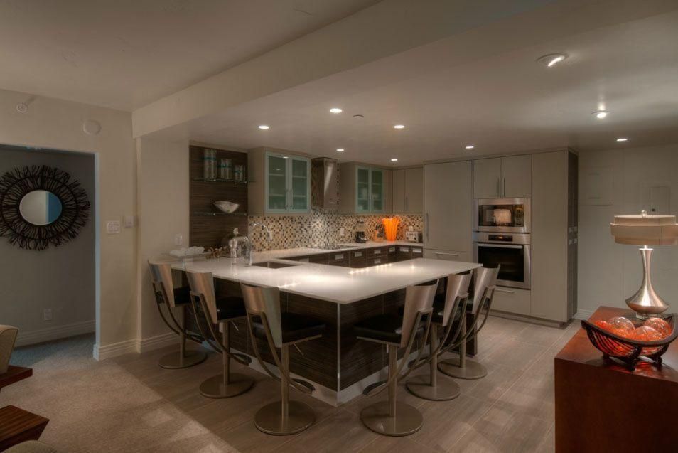Modern kitchen with a large island, barstools, recessed lighting, and stainless steel appliances