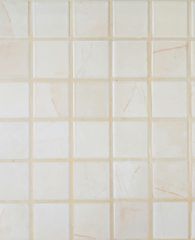 Light beige tiled wall with a grid pattern and faint discoloration marks