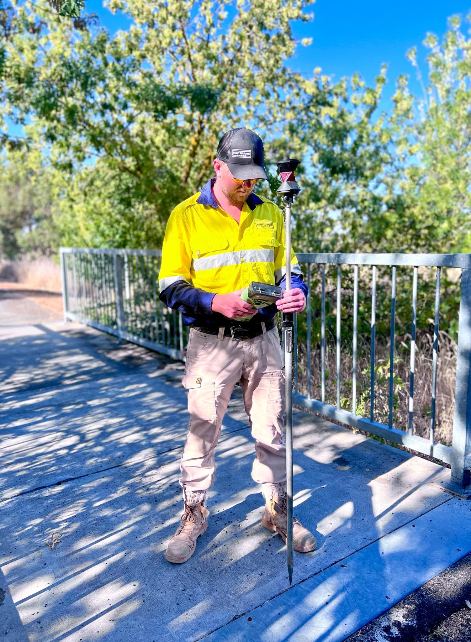 A Man Is Using A Theodolite On A Construction Site — Point to Point Surveying In Benalla, VIC