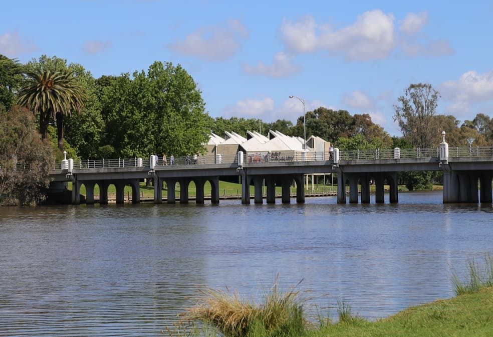 A Bridge Over A Body Of Water With Trees In The Background — Point to Point Surveying In Tatura, VIC