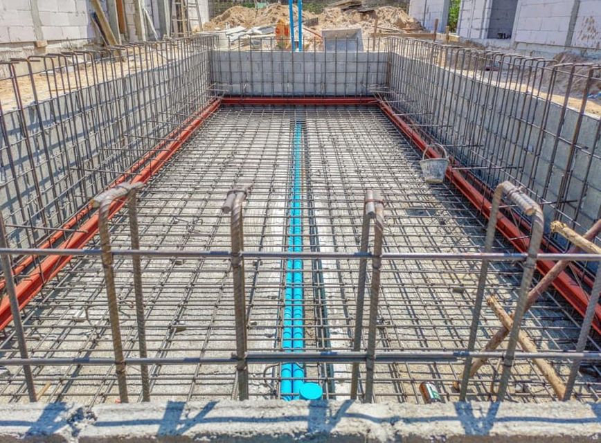 A Swimming Pool Under Construction With A Blue Pipe In The Middle — Point to Point Surveying In Tatura, VIC