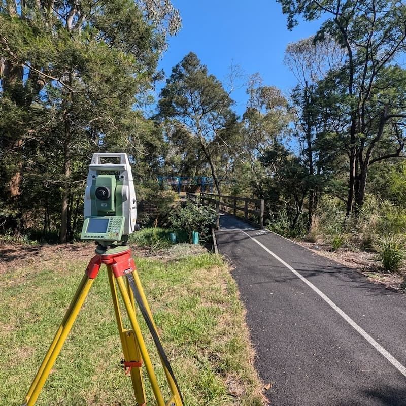 A Total Station is Sitting on a Tripod on the Side of a Road — Point to Point Surveying In Tatura, VIC