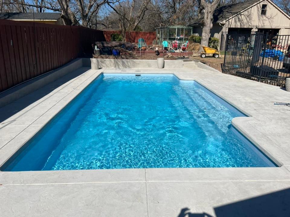 Backyard swimming pool with bright blue water and a concrete deck