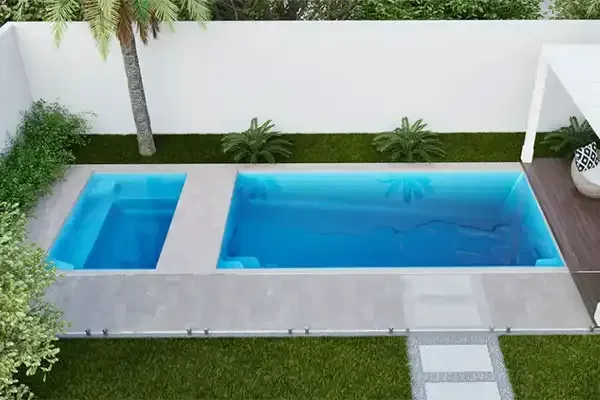 Modern backyard pool with a small square spa, blue water, and white stone decking.