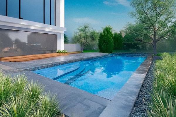 Modern backyard with a rectangular blue swimming pool beside a contemporary house and lush greenery