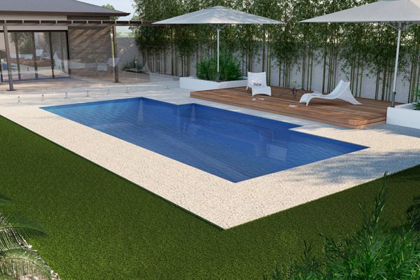 Modern backyard pool with wooden deck, lounge chairs, umbrella, and greenery