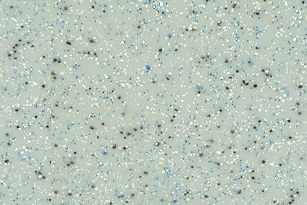 Speckled pale green textured surface with scattered blue-gray dots