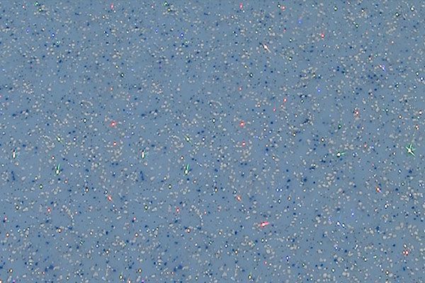 Blue speckled textured surface with scattered small red and white flecks