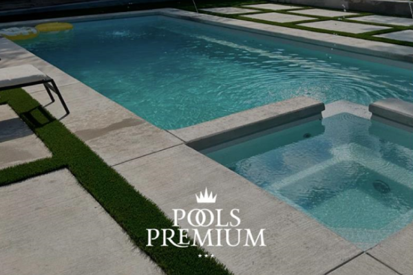 Modern backyard pool with blue water, hot tub, and tan stone patio, branded “Pools Premium”