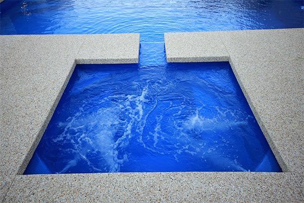 Blue water enclosed by gray concrete walls, forming a rectangular pool or canal.