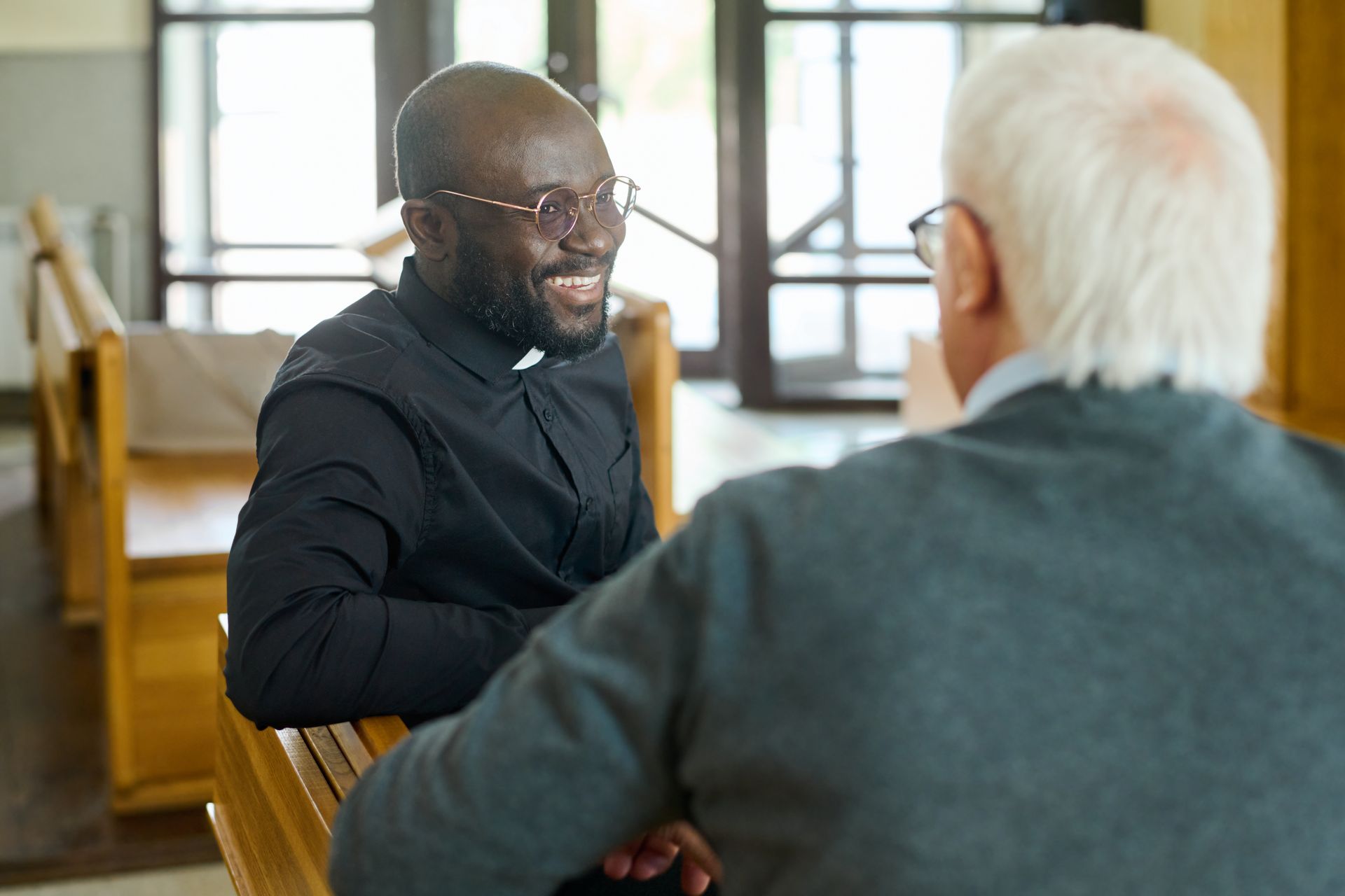 Two people in conversation at a table in a bright room