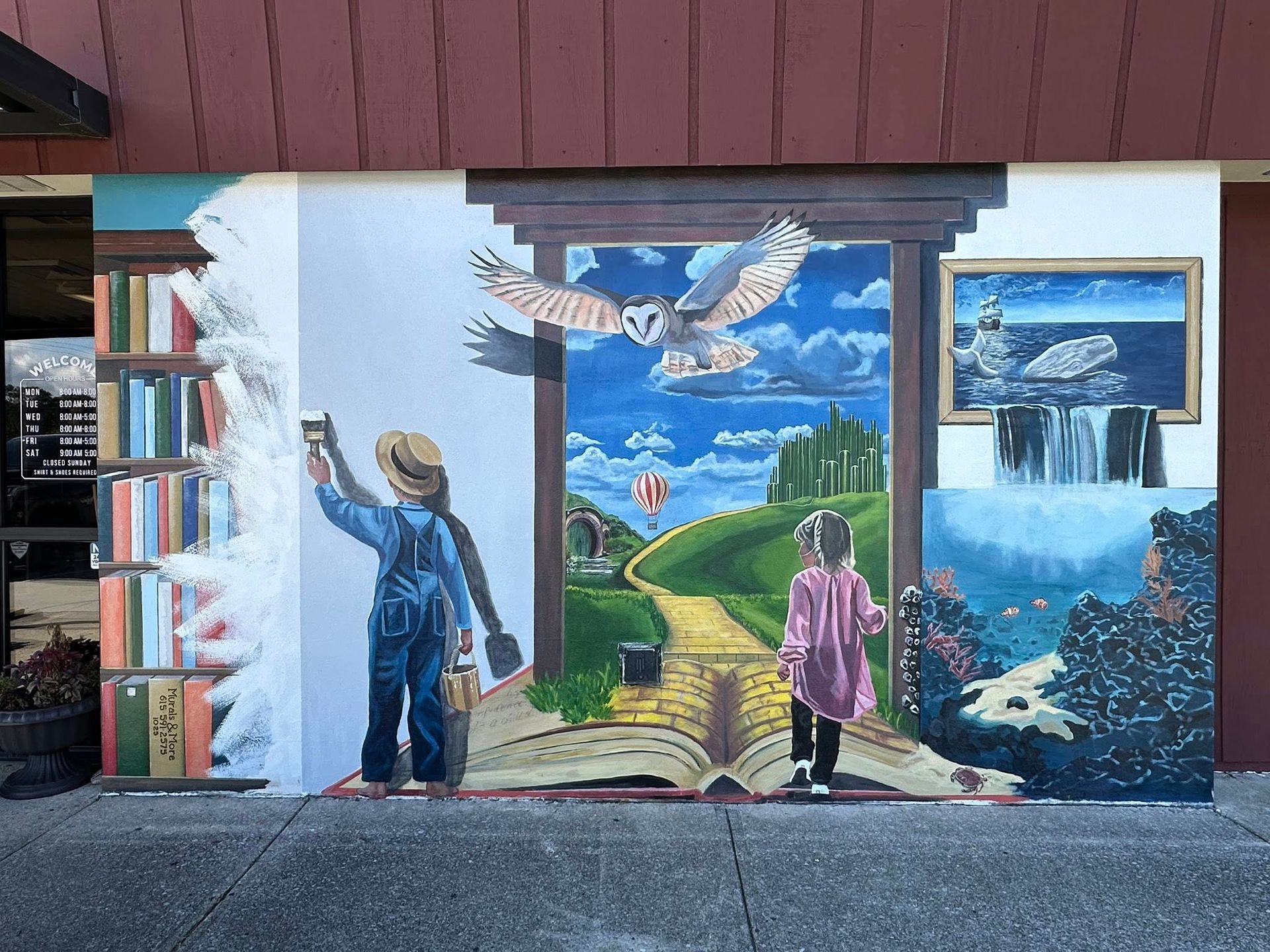 Mural of a child painting a doorway to a fantasy landscape with an owl, book, and paintings.