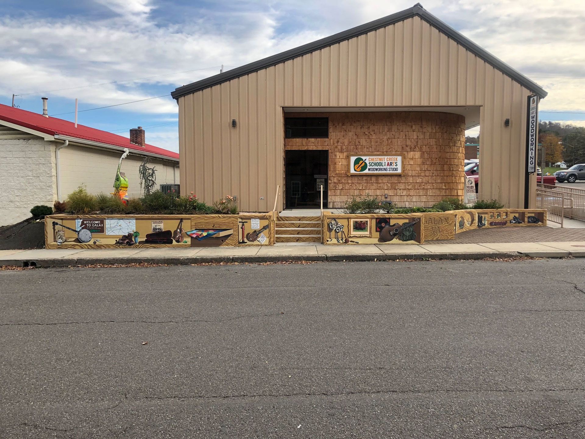 A large building with a sign on the side of it is sitting on the side of the road.