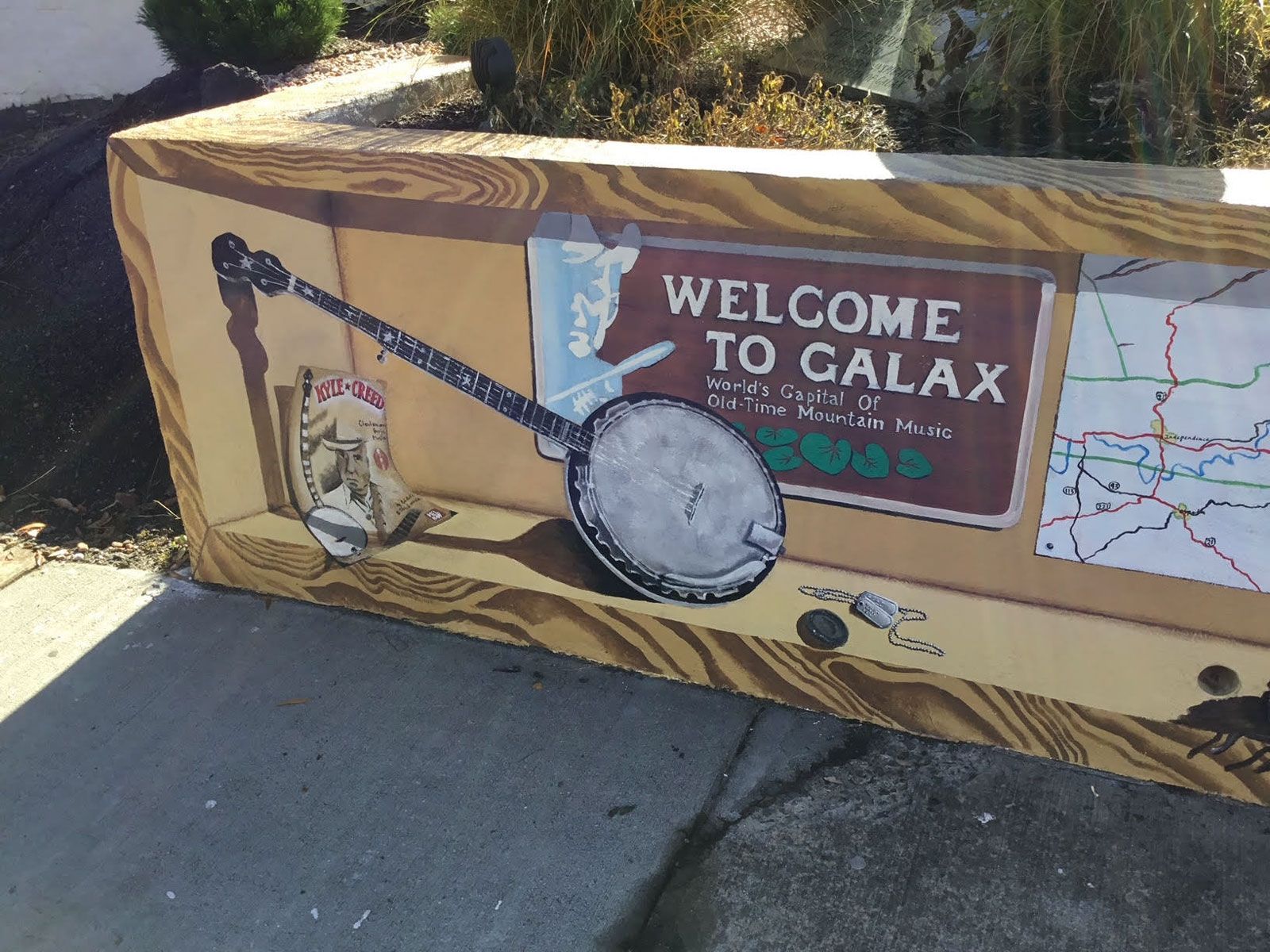 A welcome to calax sign with a banjo on it