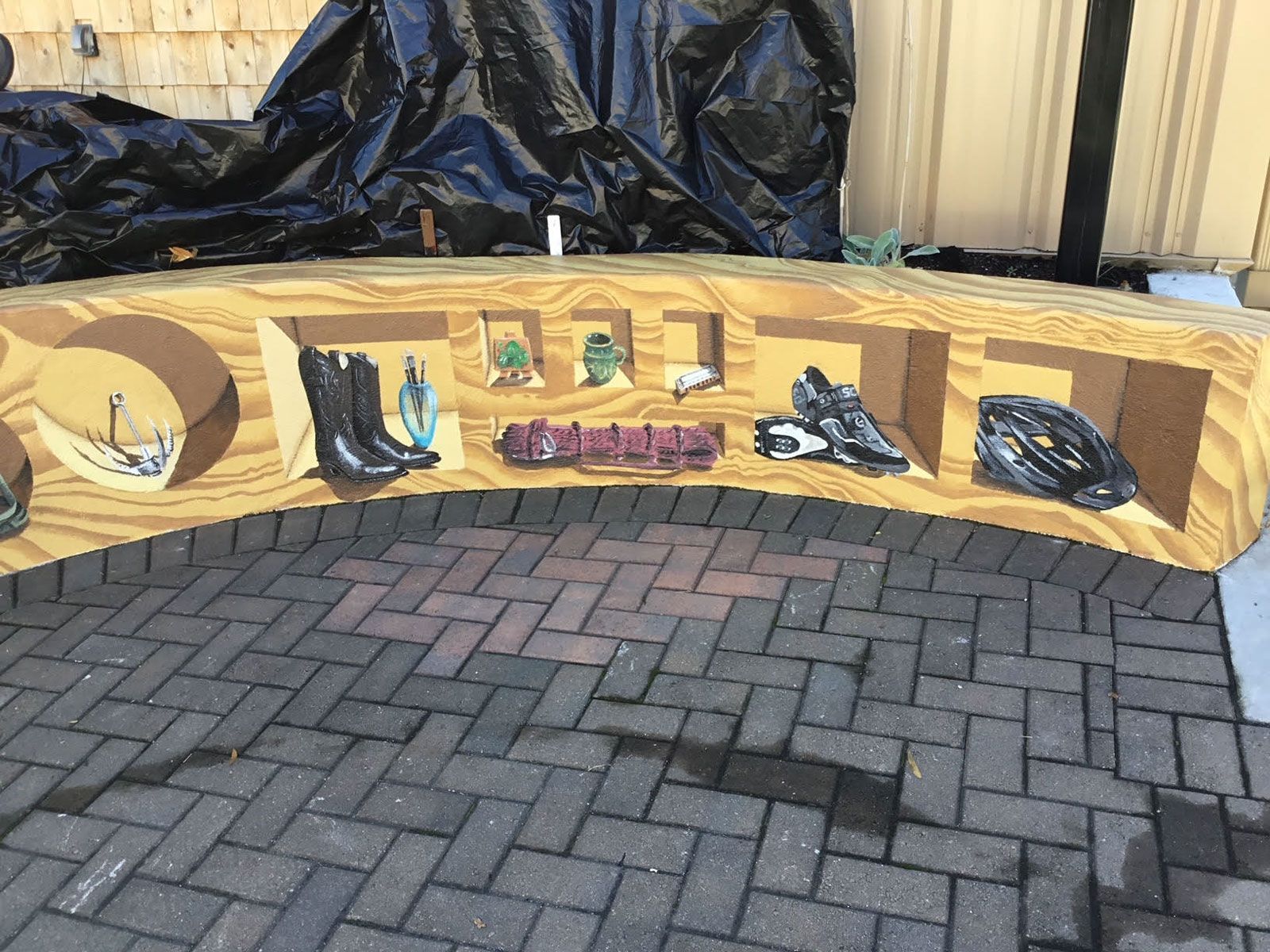 A wooden bench with a painting of shoes on it