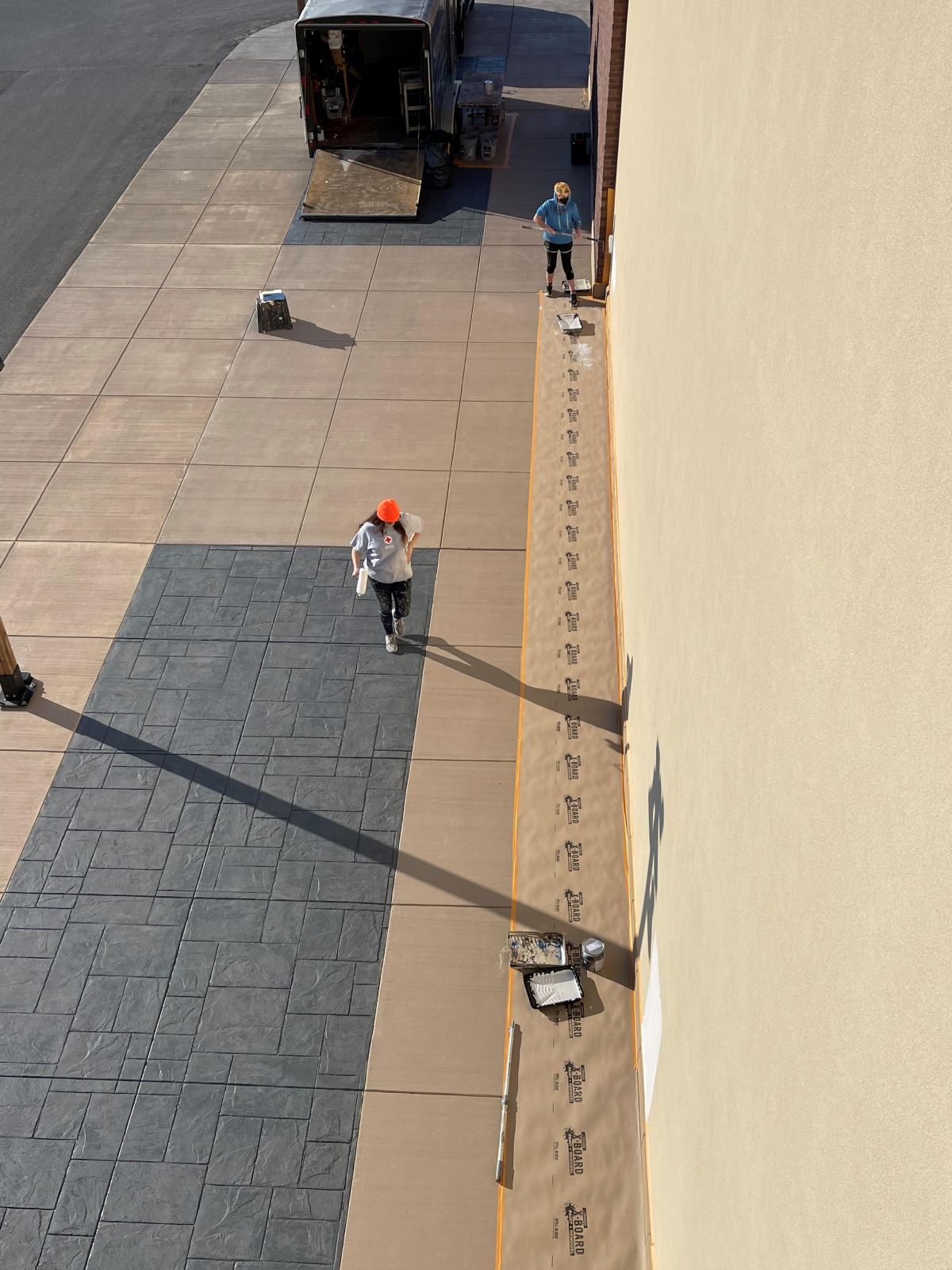 A person is walking down a sidewalk next to a building.