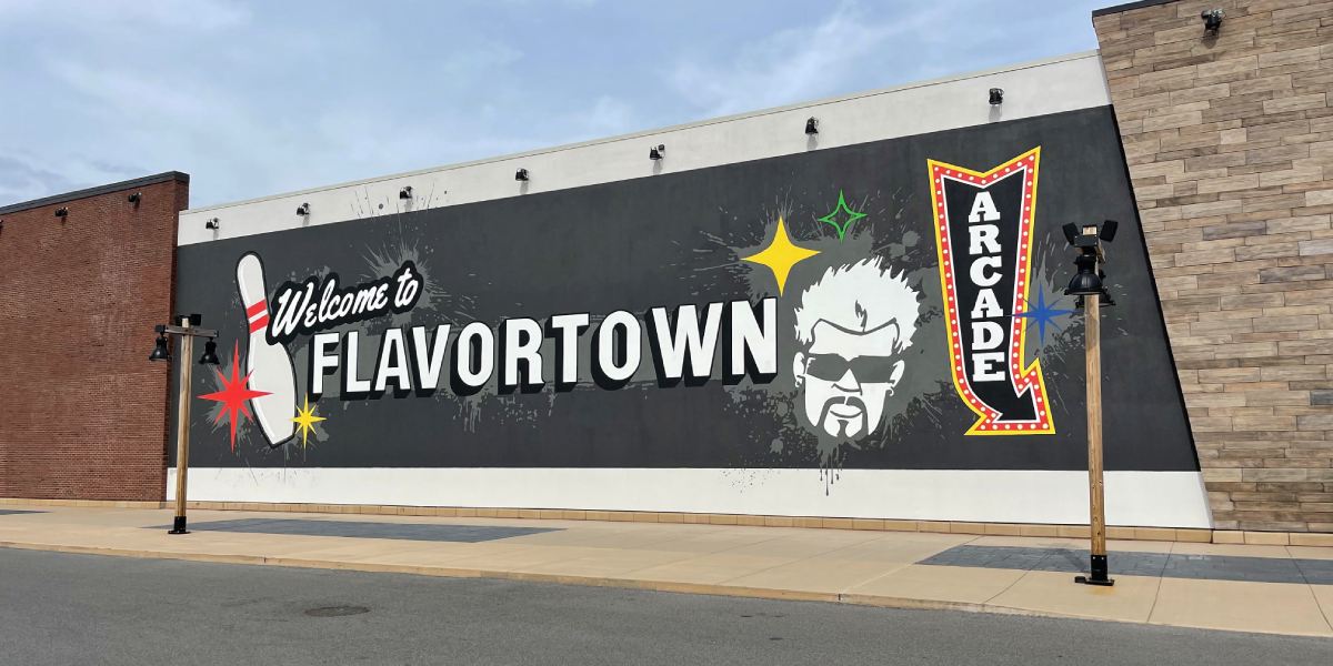 A large billboard on the side of a building that says `` welcome to flavortown ''.