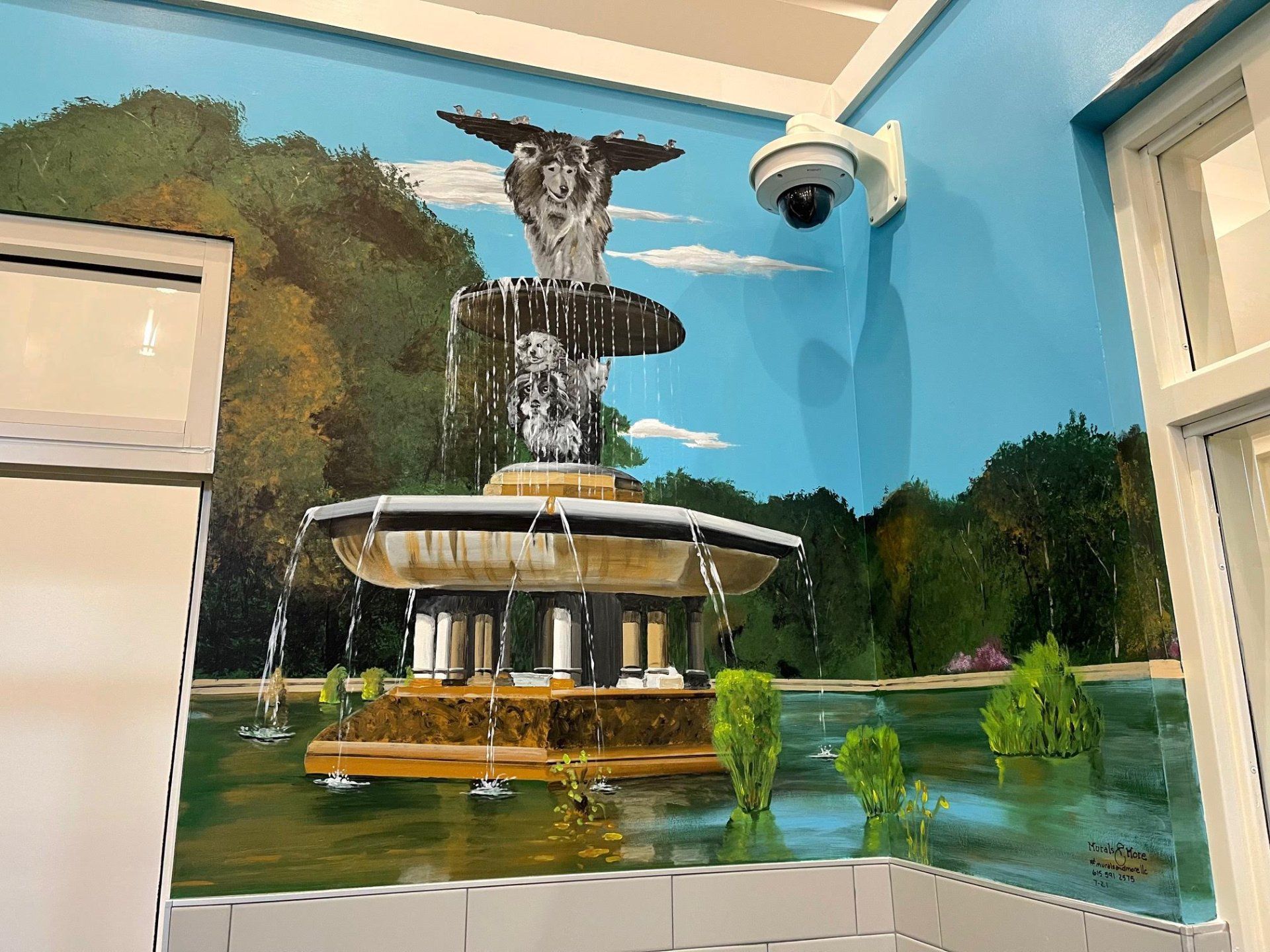 A painting of a fountain on a wall next to a security camera